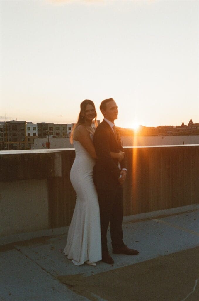 Film image of a bride and groom embracing on top of a parking deck at sunset during their Pennsylvania wedding portraits
