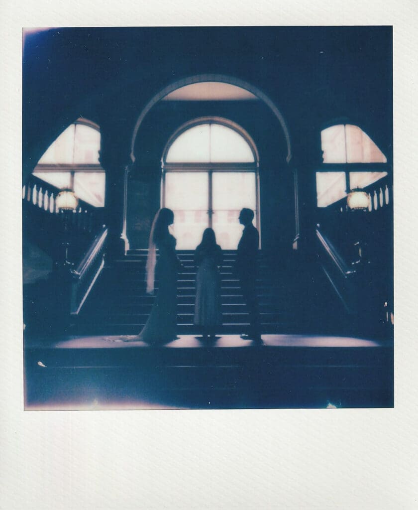 Polaroid image of bride and groom silhouetted against a large arched window during their Philadelphia wedding ceremony