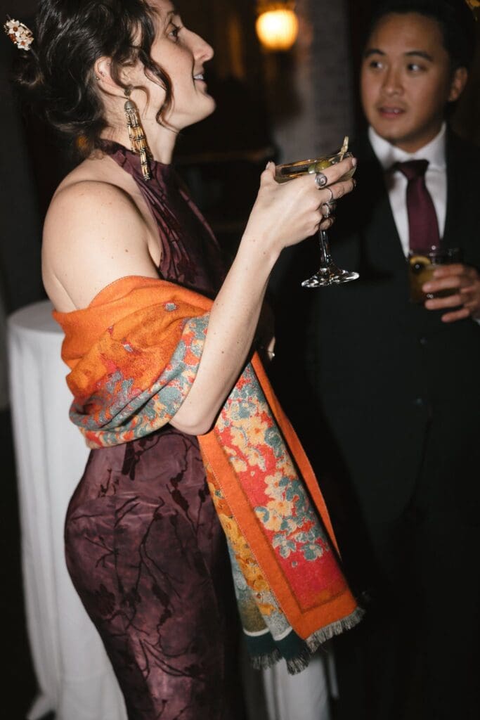 A guest in a floral wrap holding a martini during cocktail hour
