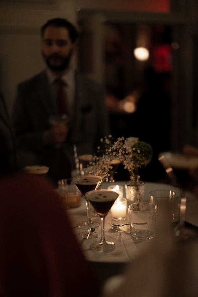 Espresso martinis on a candlelit cocktail table styled with baby's breath
