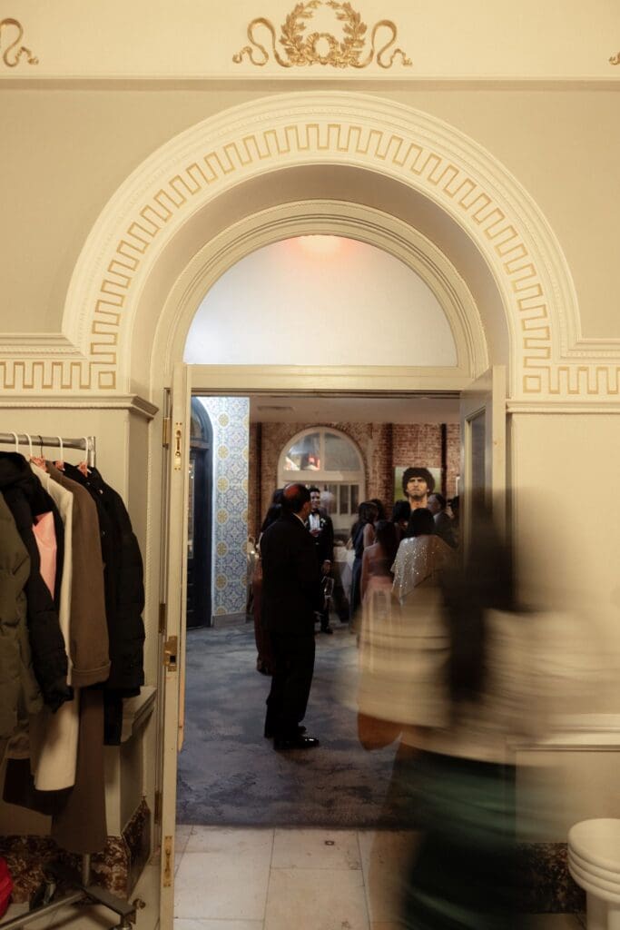 Guests mingling through a gilded archway at the historic Divine Lorraine