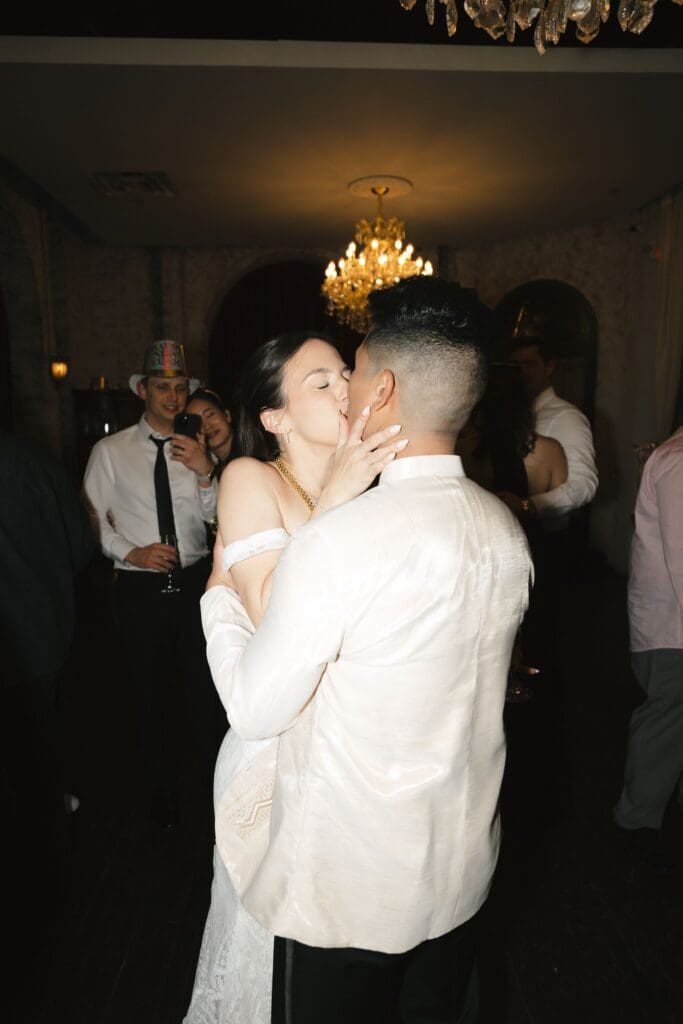 Bride and groom kissing on the dance floor during open dancing at the reception