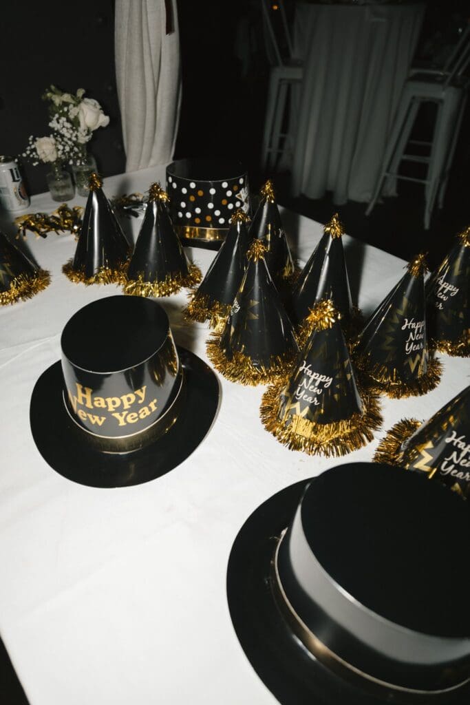 Black and gold Happy New Year's party hats sit on a table during a New Year's Eve wedding at the Divine Lorraine in Philadelphia