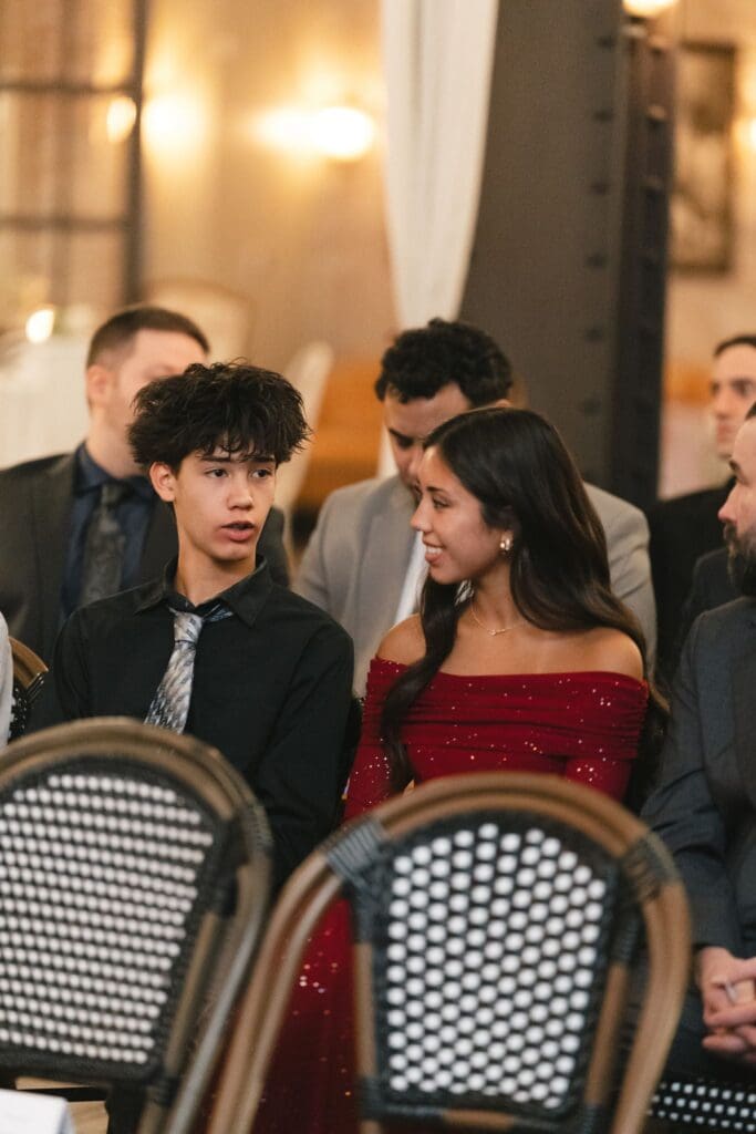 Wedding guests watching the ceremony from black bistro chairs