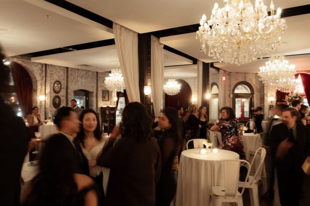 Cocktail hour mingling beneath crystal chandeliers in the historic Divine Lorraine