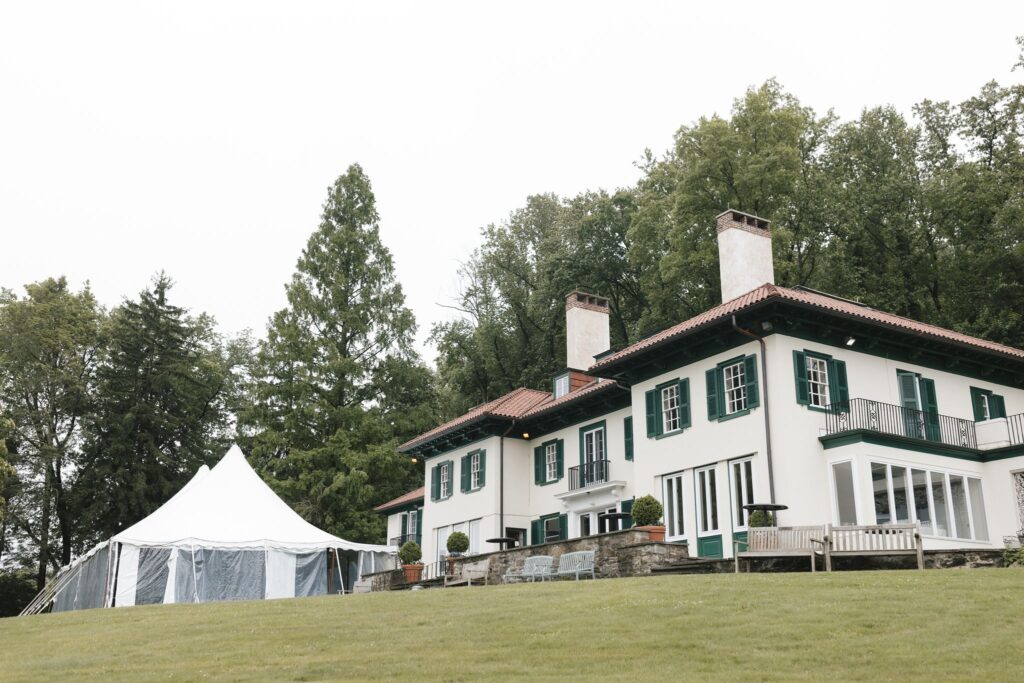 Wedding reception tent is setup in front of a Spanish revival style wedding venue