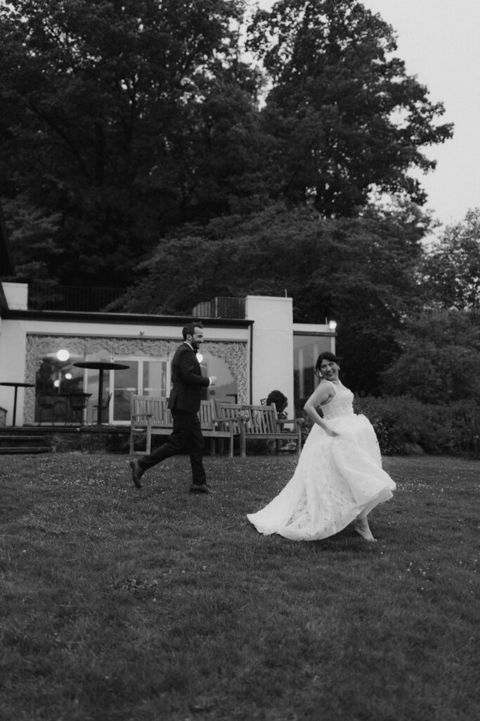 Bride and groom run together playfully in front of The Willows Villanova, a historic Philadelphia wedding venue