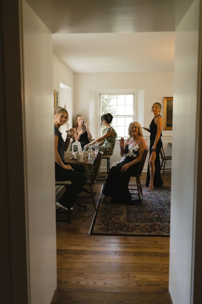 Group of bridesmaids sit together inside the bridal suite at the Inn at Fox Briar Farm, a historic Philadelphia wedding venue
