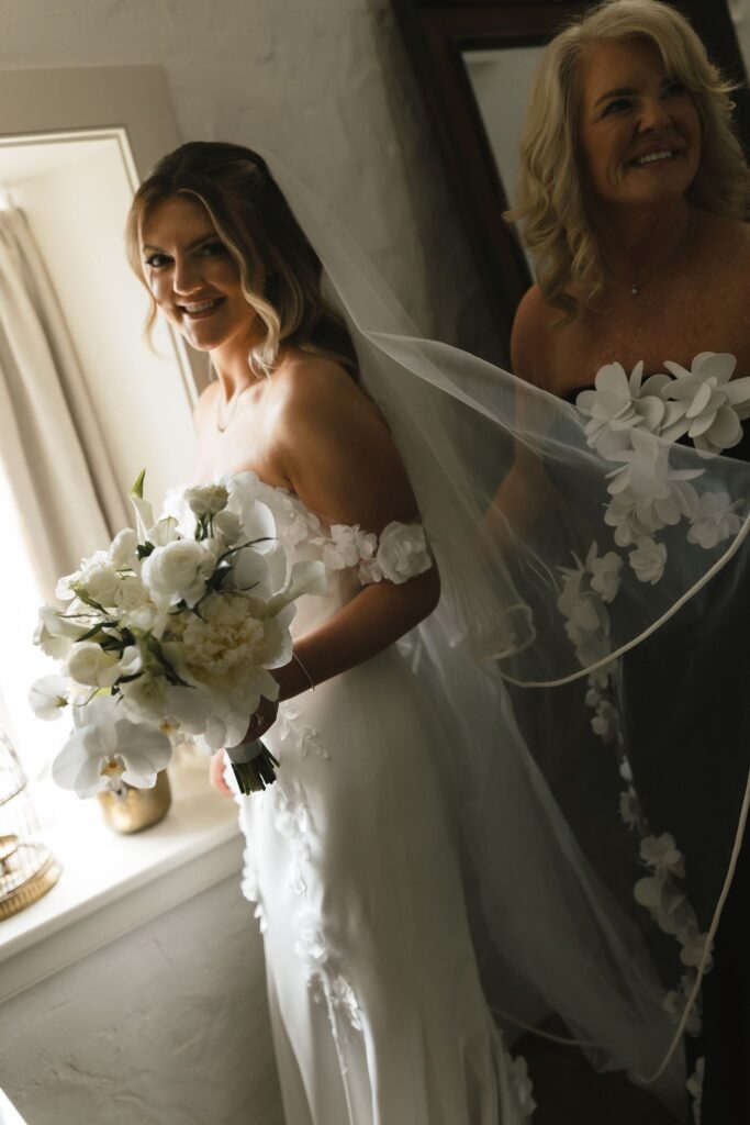 Bride's mother holds bride's veil during a getting ready portrait at the Inn at Fox Briar Farm
